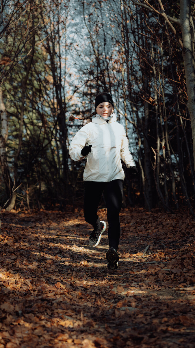 Biegaczka w odzieży i obuwiu Salomon biegnie szlakiem w Gorcach.