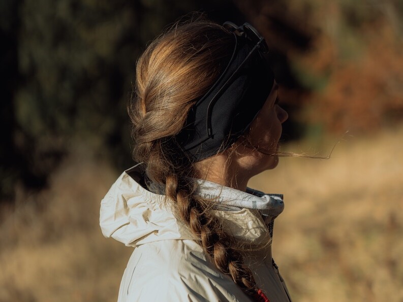 Romantyczne zdjęcie biegaczki z długim warkoczem w odzieży Salomon.